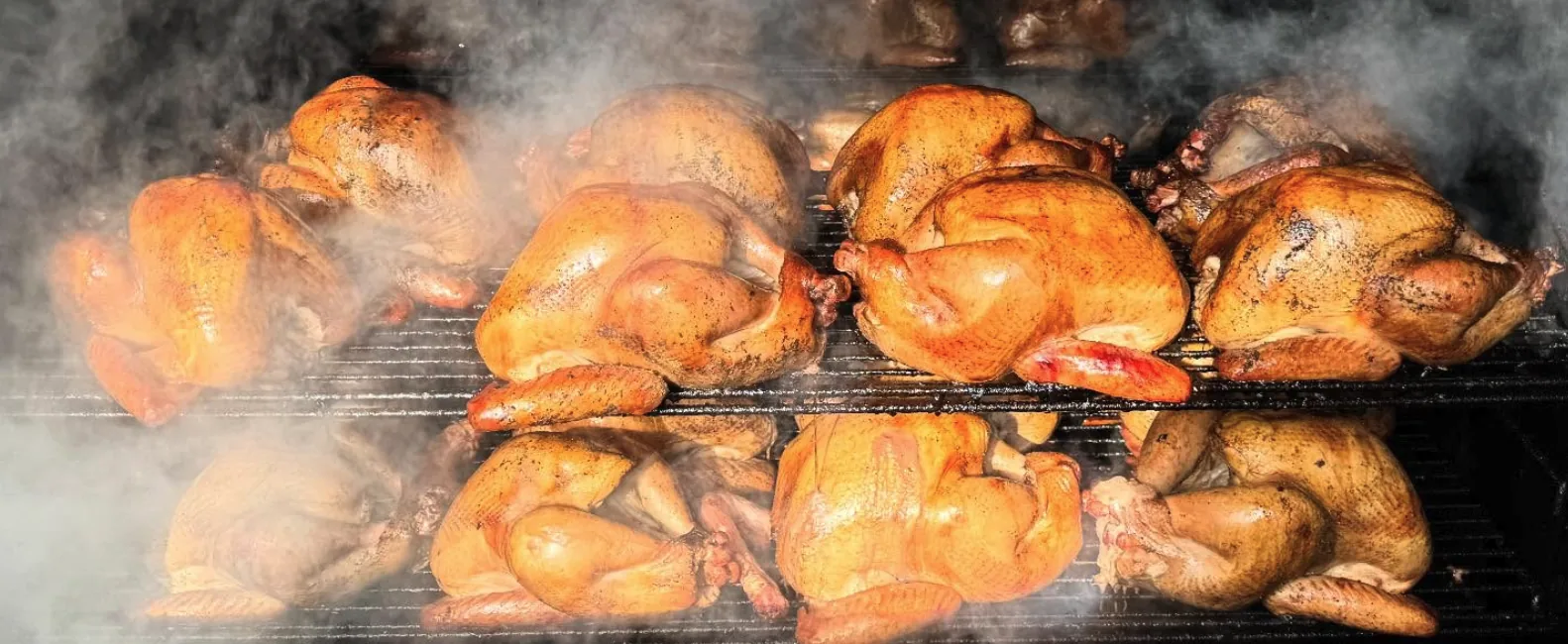 Whole chickens smoking on the pit.