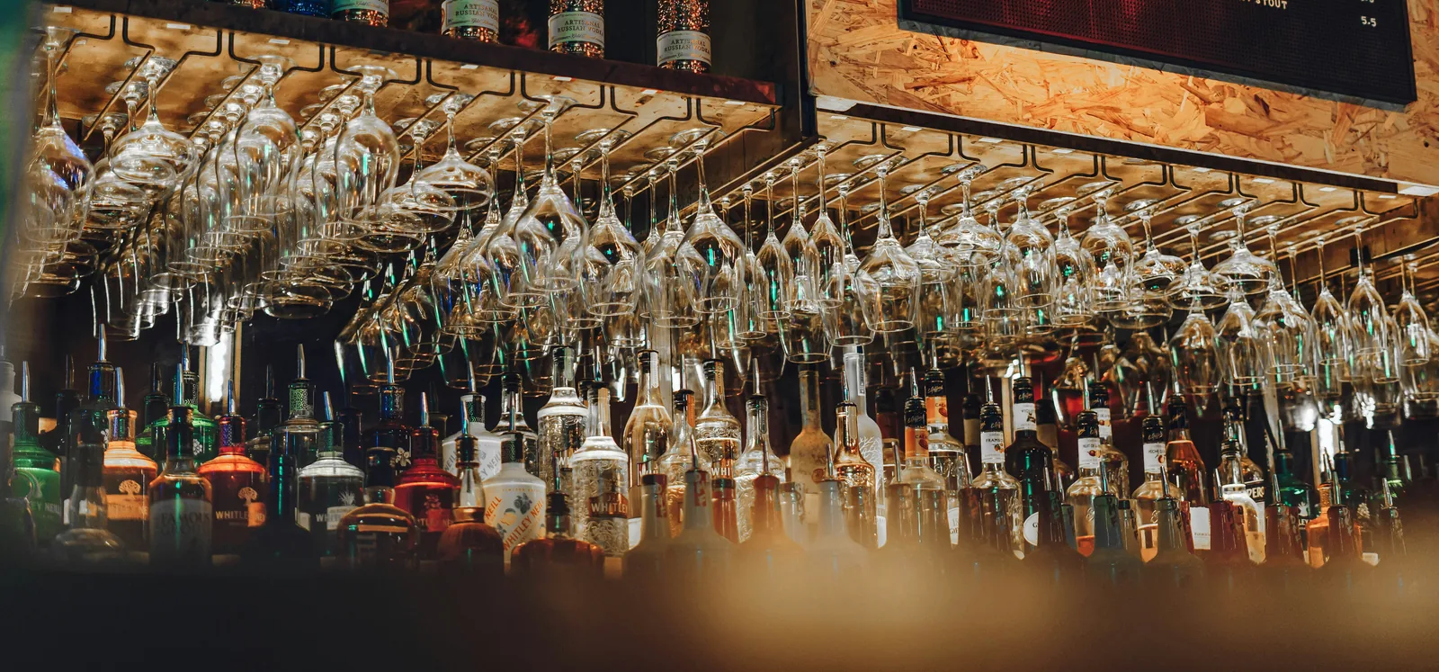 A bar set up with hanging glassware and bottles.